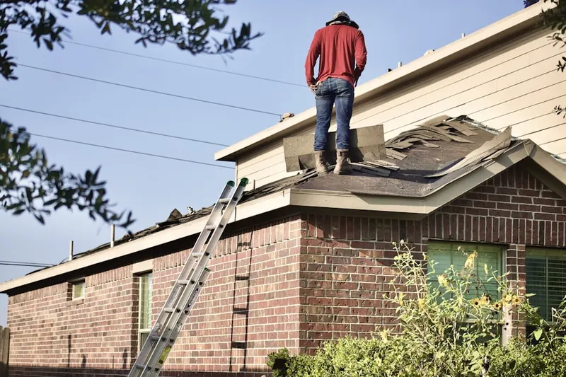 Professional roofer working on a residential roof in MacFarlane Park